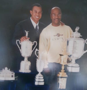 Esta es una de las fotografías más preciadas de Pete McDaniel enmarcada en su casa. Está entre él y Tiger Woods y tiene algunos de los trofeos de Woods.