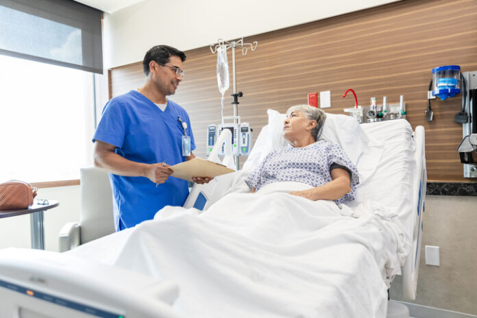 Los pacientes con un médico masculino hablan sobre los resultados de las pruebas de medicina en la prueba de los pacientes