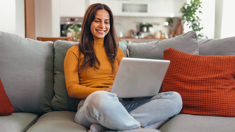 La mujer en el sofá de la computadora