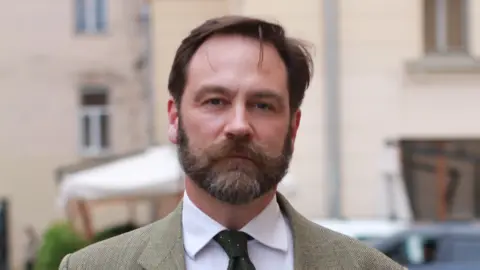 La persona que ves contribuyó la cámara. Ella tiene cabello oscuro y densas barbas oscuras.