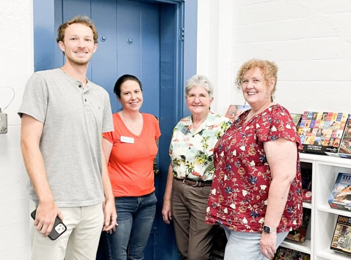 El personal de la Biblioteca de Islamorada es numeroso. Un grupo de personas paradas frente a una puerta azul.