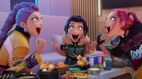 Netflix Los tres personajes principales de la película animada de Netflix KPOP DEMON HINCERS KPOP DEMON HEACHER se sientan en una mesa llena de comida y celebran. 